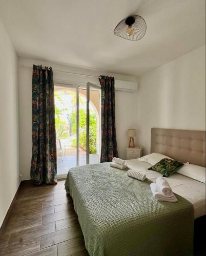 a bedroom with a bed and a window at l'Alzelle Plage in Biguglia