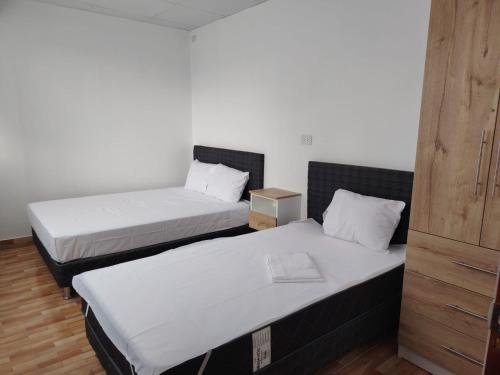 two beds in a room with white sheets at Departamento Grupo in Lima