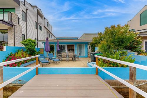a wooden walkway leading to a house with a patio at Balboa Blue Lagoon in Newport Beach