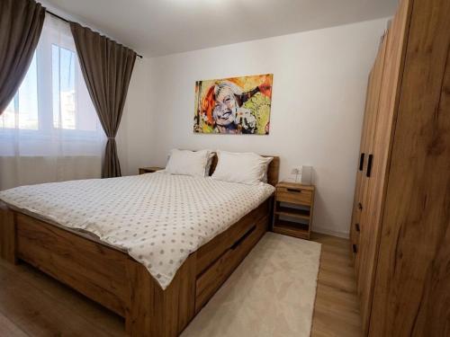 un dormitorio con una cama y un cuadro en la pared en Apartament Theodora, en Curtea de Argeş