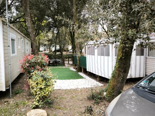 a yard with two white campsites and a green lawn at Tiny house in Saint-Brévin-lʼOcéan