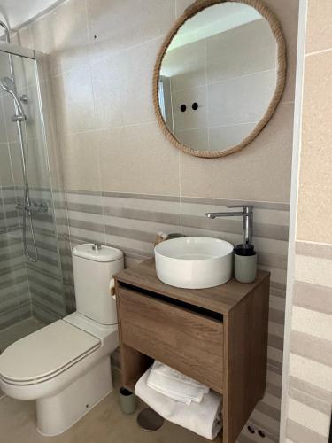 a bathroom with a sink and a toilet and a mirror at Atalaya Green Nest in Estepona