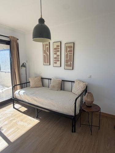 a bed sitting in a room with a pendant light at Atalaya Green Nest in Estepona