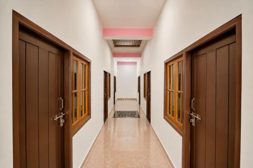 a corridor with brown doors in a hallway at SPOT ON ROYAL KING HOTEL in Lucknow
