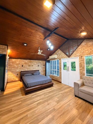 a bedroom with a bed and a couch in a room at Villas by Helanka in Gonawala