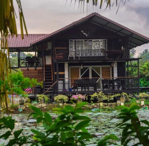 a house with a pond in front of it at Villas by Helanka in Gonawala