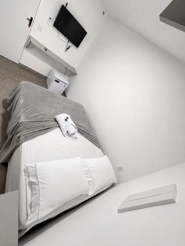a white bedroom with a bed with a stuffed animal on it at Manaira Suite 01 in João Pessoa