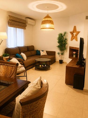 a living room with a couch and a table at Casa familiar con patio privado y piscina comunitaria cerca de la playa in Málaga