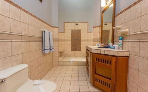 a bathroom with a tub and a toilet and a sink at Casa Pura Paz in Puntarenas