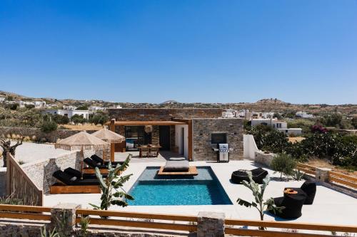a villa with a swimming pool in the desert at Stone Waves Αpartments & Villas in Agios Arsenios