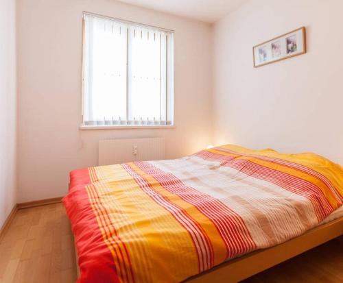 a bedroom with a bed with a colorful blanket at Suite mit Blick auf den Grünberg - 65 m2 in Gmunden