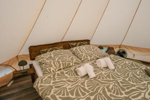 a bed in a tent with two pillows on it at Zálesie Glamping in Kostolná Ves
