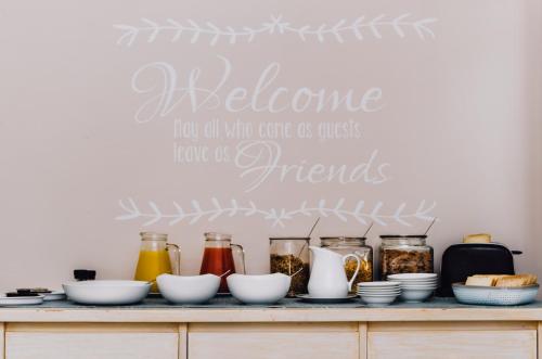a shelf with food on it with a sign that says welcome for all who come at Admirals Lodge Guest House and Brightways self catering apartments in Port Elizabeth
