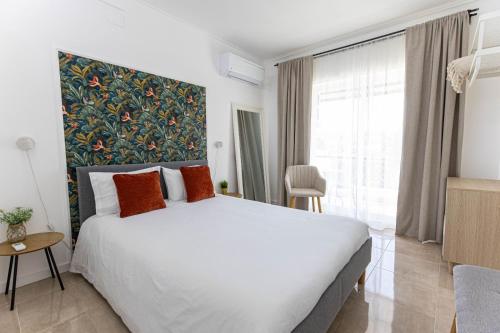 a bedroom with a large bed and a large window at Quinta dos Canais in Setúbal