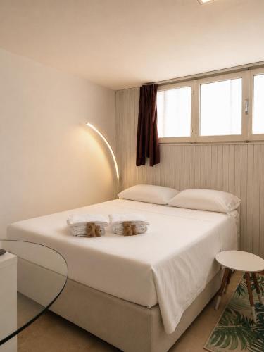 a bedroom with a bed with two bowls on it at Petit Biscuit - Wi-Fi - Kitchen - AC - Parking in Lido di Camaiore