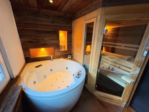 a bathroom with a large tub and a shower at Alpine Chic Escape with Spa & Panoramic Views in Engelberg
