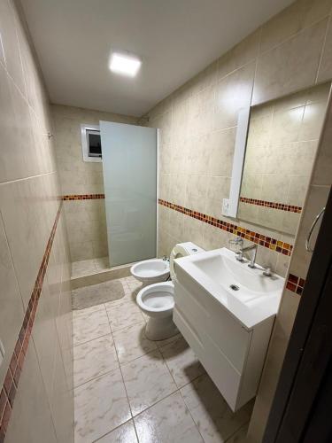 a bathroom with a toilet and a sink and a mirror at Olivia apart in Chajarí