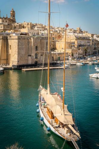 a sail boat docked in a harbor with a city at Royale Sainte Hélène Boutique Hotel in Birkirkara