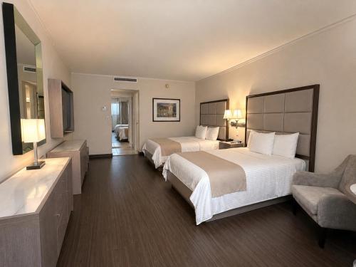 a hotel room with two beds and a chair at Safi Royal Luxury Centro in Monterrey
