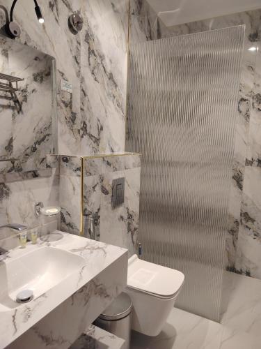 a bathroom with a sink and a toilet and a mirror at فندق لوشال LECHAL Hotel in Medina
