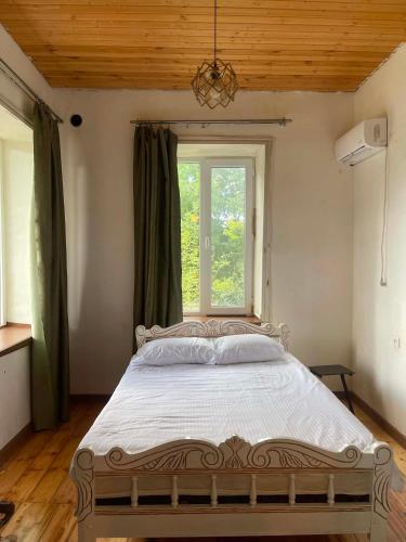 a large bed in a room with a window at Rails and Vines in Tsinandali
