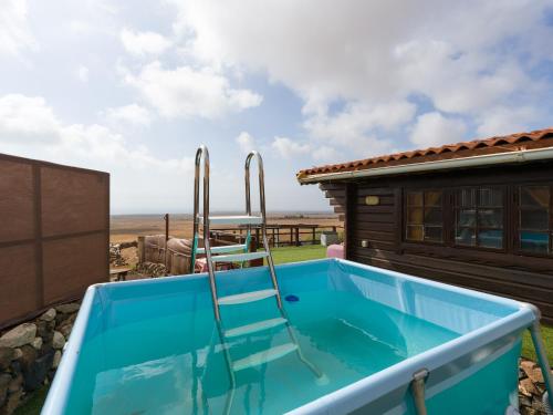 a lap pool with a chair in the middle of a house at La Maxada Luz Maria in El Cotillo