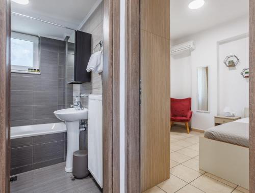 a bathroom with a sink and a toilet and a tub at Arivaro Apartment in Souda
