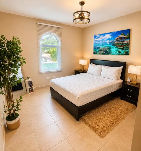 a bedroom with a bed and a large window at Ocean View Serenity in Cupecoy