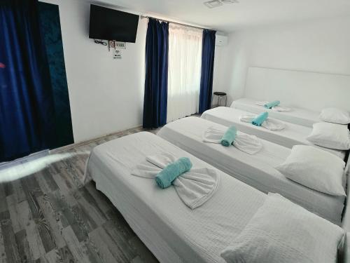 ein Zimmer mit drei Betten, auf denen Handtücher lagen in der Unterkunft Ridos in Constanţa