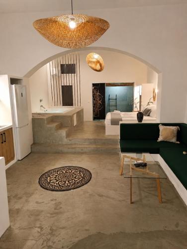 a living room with a green couch and a bathroom at Ιόνια Γαλήνη Pool Spa Suite in Parga