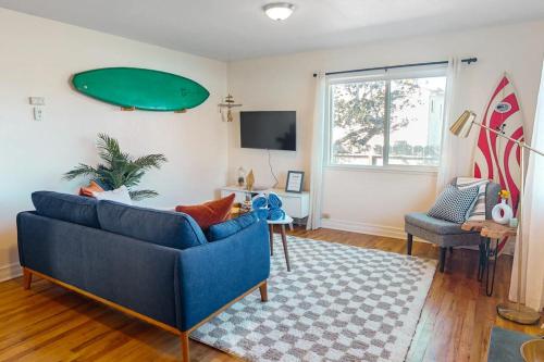 a living room with a blue couch and a surfboard on the wall at Deep Blue Seaside in Monterey