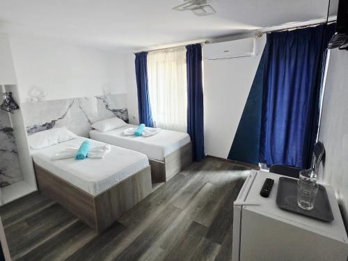 ein kleines Zimmer mit zwei Betten und einem Waschbecken in der Unterkunft Ridos in Constanţa
