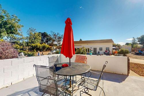 a table with a red umbrella and two chairs at See Star Ranch in Nipomo