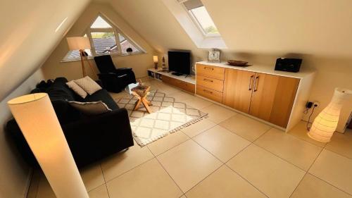 a living room with a couch and a tv at Ferienwohnung Grachtenhimmel in Greetsiel
