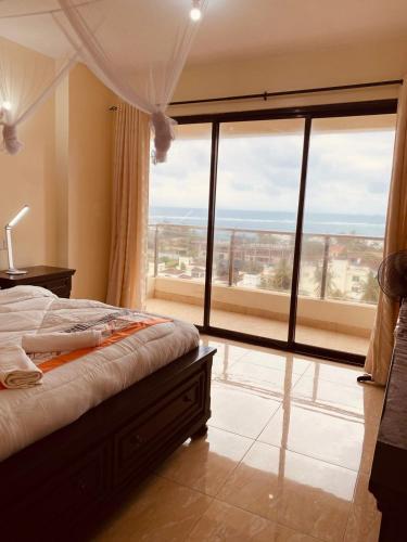 a bedroom with a bed and a large window at Seaview homestay on Third avenue beach apt- nyali in Mombasa