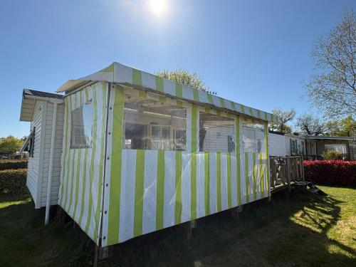 a yellow and white mobile home in a yard at Mobil home in Ambon