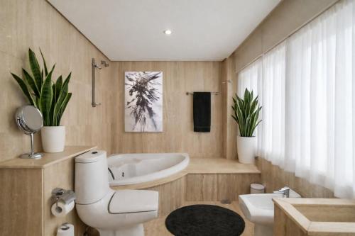 a bathroom with a tub and a toilet and a sink at Gran Room do Mar in Oya