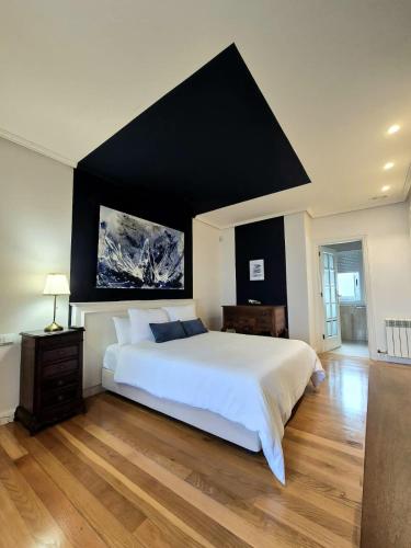 a bedroom with a large white bed with a black wall at Ocean Breeze in Oya