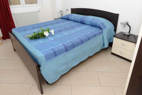 una cama con un edredón azul y flores en ella en Casa Ciclamino, en Vercana