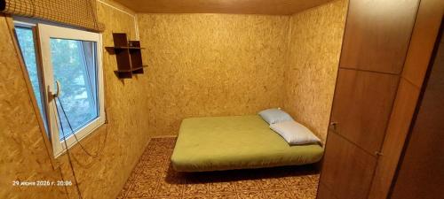 a small room with a bed and a window at ДАЧА на Студенческой in Karolino-Buhaz