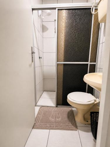 a small bathroom with a toilet and a shower at Angico Motel in Passo Fundo