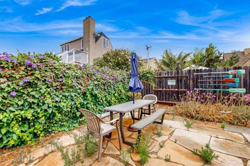 a patio with a table and chairs and an umbrella at Sailaway Cabin A in Ventura