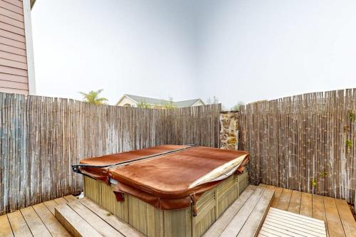 a wooden fence with a wooden tub on a patio at Dune Delight in Arroyo Grande