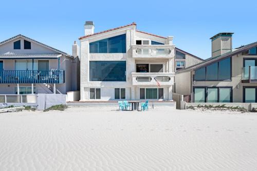 a building on the beach with two chairs in the sand at Sandcastle by the Sea in Oxnard