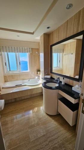 a bathroom with a large tub and a sink and a bath tub at Ocean View Room Oia in Oya