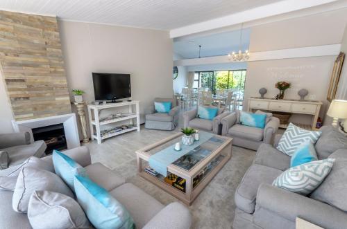 a living room with couches and a tv at Admirals Lodge Guest House and Brightways self catering apartments in Port Elizabeth
