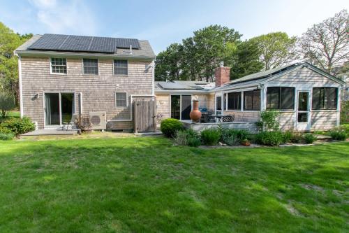 a house with a solar roof on a yard at Spacious Mins from Beach & Dogs Welcome in Eastham