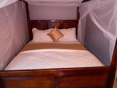 a small bed in a tent with white sheets and pillows at Omuka owaawe resort in Biguri