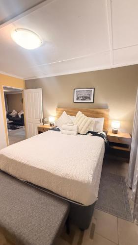 a bedroom with a large bed and two night stands at 2 Bedrooom Self Catering Unit, East London, 5241, South Africa, KuGompo City in Dorchester Heights 