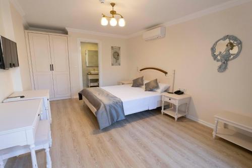 a bedroom with a white bed and white cabinets at Icarus Alaçatı in Çeşme